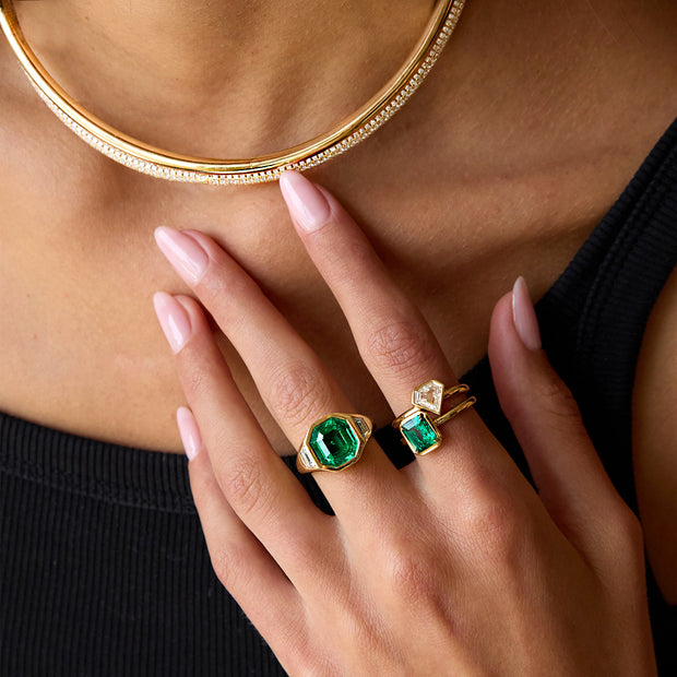 OCTAGONAL EMERALD AND TRAPEZOID DIAMOND BEZEL RING